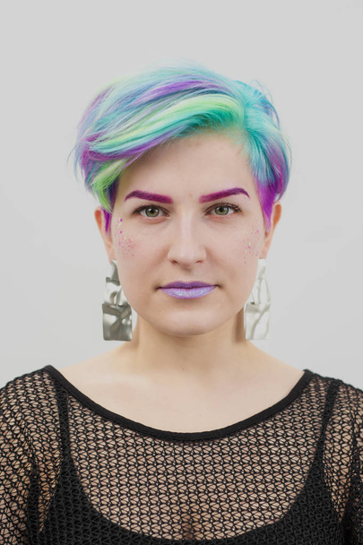 Young beautiful woman with dyed blue and green hair. Pixie bob short haircut The concept of hair styling. - Foto, imagen