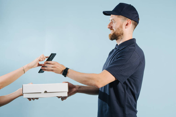 Mujer mano aceptar una entrega de caja de un mensajero mediante la firma en un teléfono inteligente
 - Foto, imagen