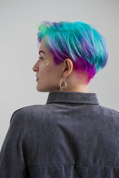 Young beautiful woman with dyed blue and green hair. Pixie bob short haircut The concept of hair styling. - Foto, Imagen