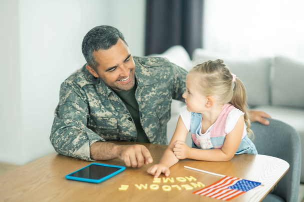 Handsome military officer smiling to his lovely daughter - Photo, Image