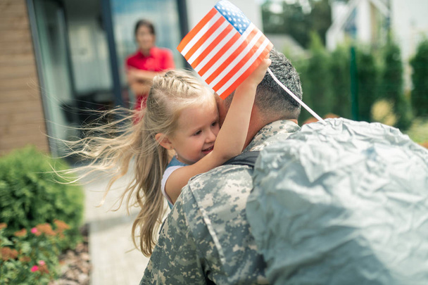 Daughter holding little American flag hugging daddy tight - Photo, Image