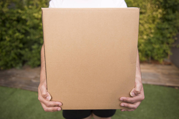 Man Holds Carton Box In Hands, shipping delivery box in hands, carton package. Parcel delivery with good depth of field. - Fotografie, Obrázek