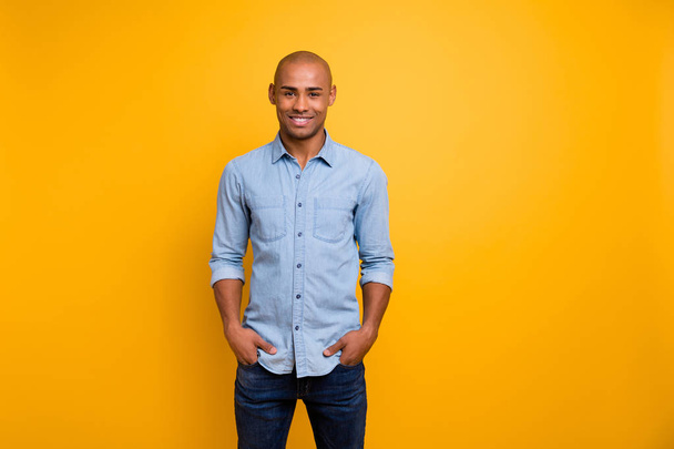 Portrait of pretty guy feel glad hands palms pockets isolated over yellow background - Fotó, kép