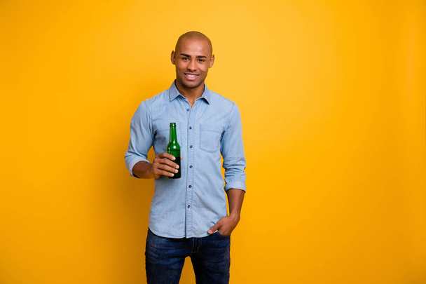 Closeup photo of dark skin macho raise hold hand beer bottle sport bar wear jeans denim shirt isolated bright yellow background - Fotoğraf, Görsel