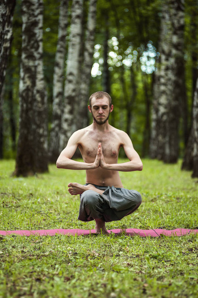 Yoga man mediteren bij zonsondergang. Mannelijk model van meditatie in seren - Foto, afbeelding