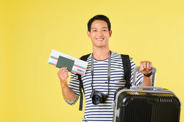 Портрет молодої в'єтнамської людини з великою валізою і посадковий талон готовий подорожувати літаком  - Фото, зображення