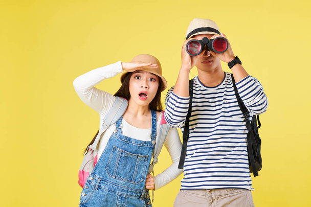 Sorprendido joven pareja vietnamita con prismáticos mirando curioso turismo
 - Foto, Imagen