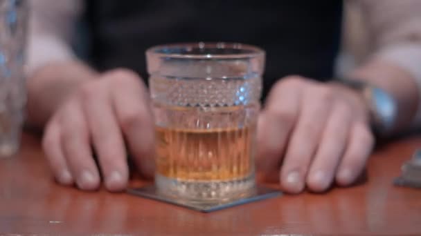 Herrasmiesbaarimikko valmistaa lasillisen viskiä pallojäällä, jäämuotilla
 - Materiaali, video