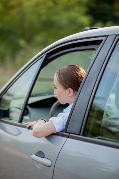 Portrait shot through windshield of pretty woman in car - Foto, immagini