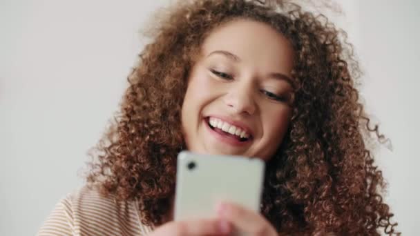Közelről mosolygó tizenéves lány mobiltelefonnal  - Felvétel, videó