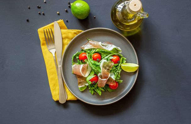Salad with arugula, tomatoes and prosciutto. Italian cuisine. Healthy eating. Diet. - Foto, Bild