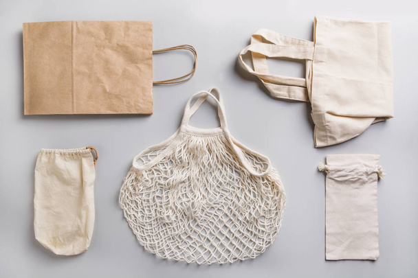 Paper, cotton and mesh bags for zero waste shopping on grey. Zero waste concept. - Fotó, kép
