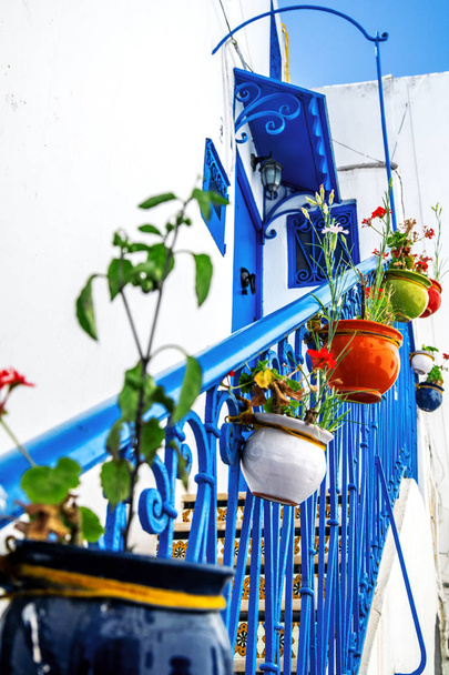 Bloempotten sieren de blauwe trap die leidt naar de deur naar het huis. Tunesië. - Foto, afbeelding