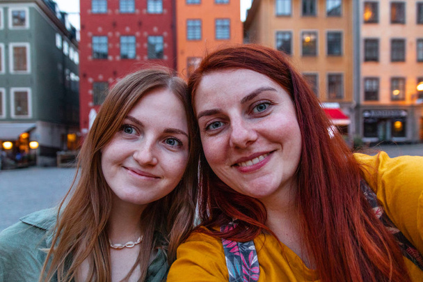 Two teenage girls using smartphone,taking a selfie , sitting together. - Fotografie, Obrázek