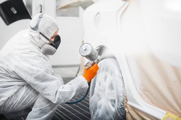 Spraying the paint to the car. Paint coating business. - Photo, Image