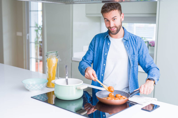 Красивий чоловік готує макарони вдома
 - Фото, зображення