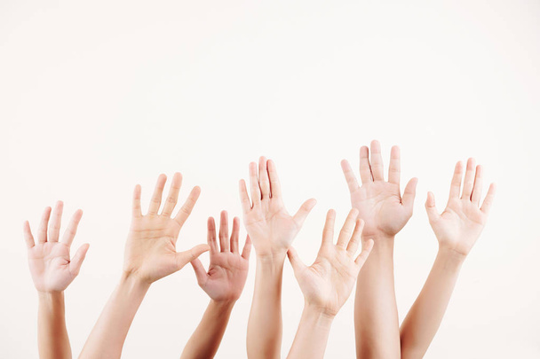 Lähikuva joukosta ihmisiä ojentaa kätensä ylös he äänestävät valkoinen tausta
 - Valokuva, kuva