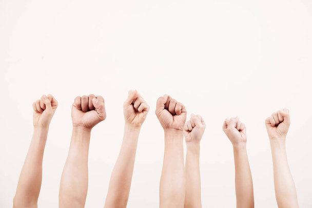 Close-up do grupo empresarial levantando os punhos e demonstrando poder isolado no fundo branco
 - Foto, Imagem
