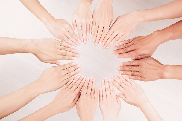 Gros plan d'un groupe multiethnique de personnes qui mettent la main sur la table sous forme de cercle
 - Photo, image