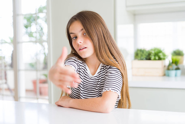 Mooi jong meisje Kid dragen strepen t-shirt lachend vriendelijk aanbieden Handshake als groet en gastvrij. Succesvolle Business. - Foto, afbeelding