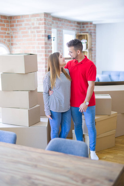 Young beautiful couple in love around cardboard boxes moving to  - Foto, immagini