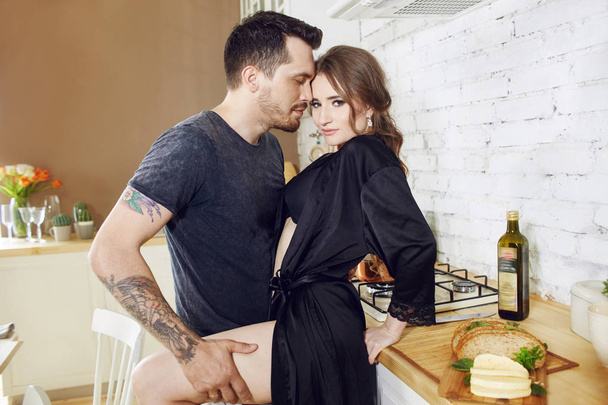 Πρωινό ζευγάρι που λατρεύει την κουζίνα. Ένας άντρας και μια γυναίενα - Φωτογραφία, εικόνα