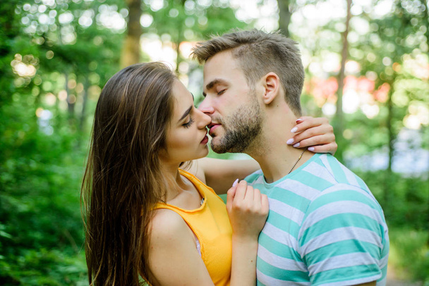 Couple in love kissing with passion outdoors. Man and woman attractive lovers romantic kiss. Passionate kiss concept. Giving kiss. Seduction and foreplay. Sensual kiss of lovely couple close up - 写真・画像