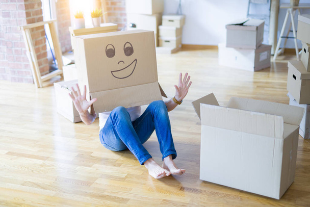 Man wearing funny cardboard box with happy face, moving to a new house, crazy and creative concept - Фото, зображення