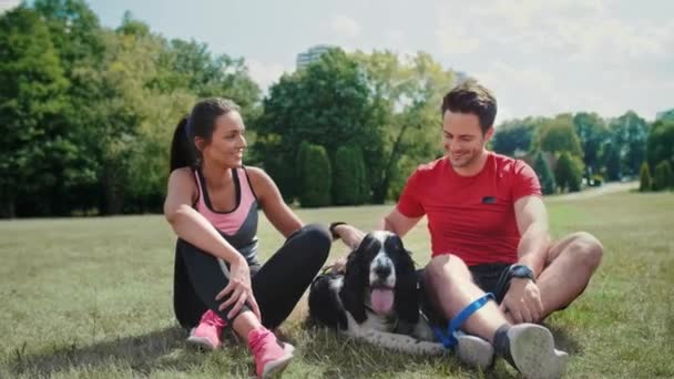 Paar und Hund ruhen sich nach dem Training an der frischen Luft aus  - Filmmaterial, Video