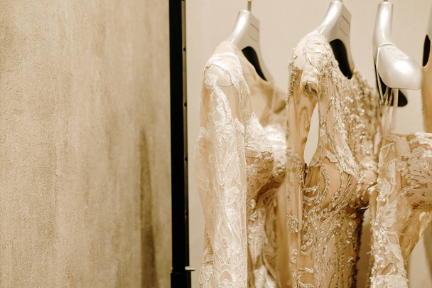 Vestidos de novia de crema colgando en el estante - Foto, imagen
