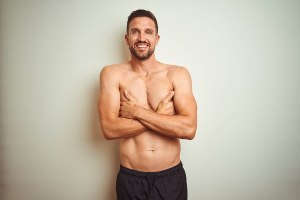 Young handsome shirtless man over isolated background happy face smiling with crossed arms looking at the camera. Positive person. - Foto, Imagem