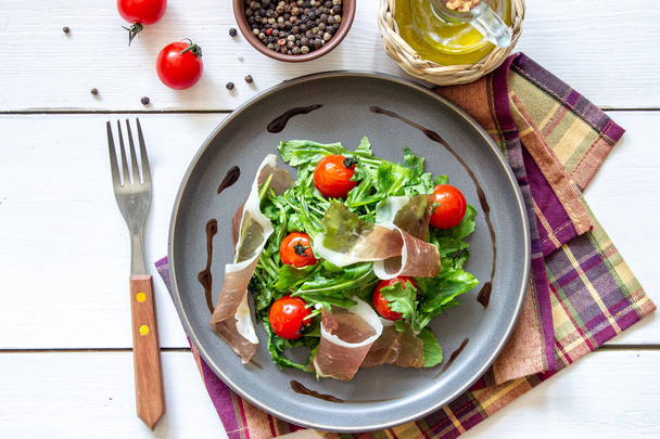 Salad with arugula, tomatoes and prosciutto. Italian cuisine. Healthy eating. Diet. - Foto, imagen