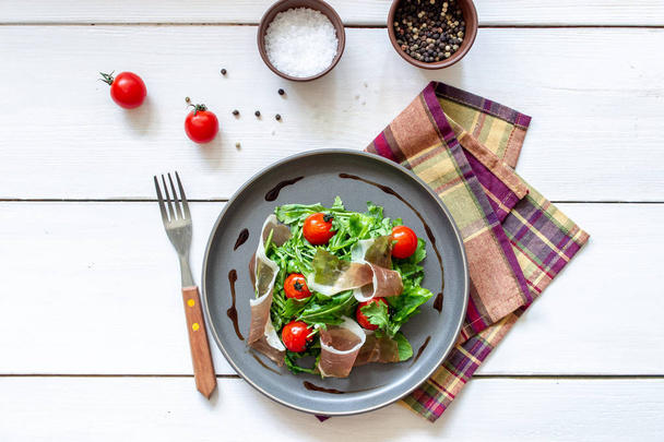 Salad with arugula, tomatoes and prosciutto. Italian cuisine. Healthy eating. Diet. - Foto, imagen
