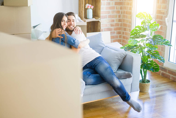 Bella coppia che si abbraccia in amore sul divano, molto felice sorridente eccitato per la nuova casa
 - Foto, immagini