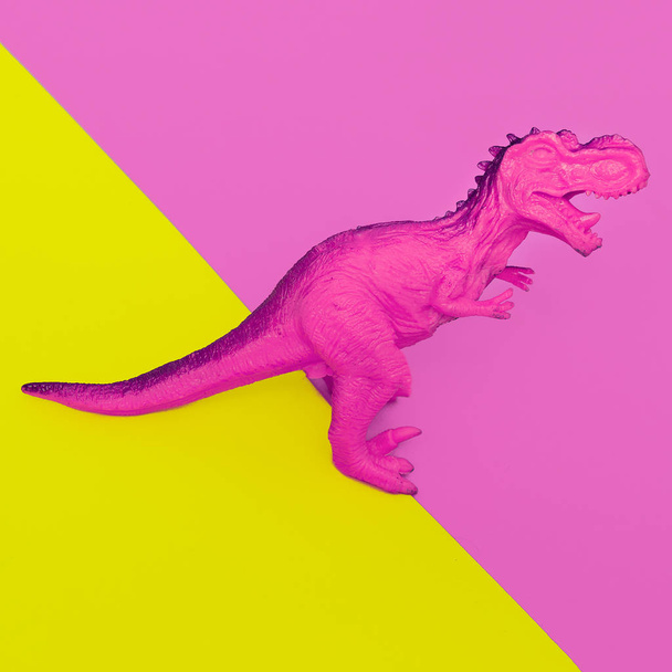 Pink Dinosaur toy on colored background. Minimal flat lay art. - Foto, immagini