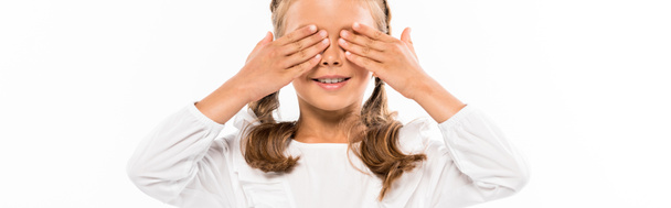 panoramic shot of happy kid covering eyes with hands isolated on white - Fotó, kép