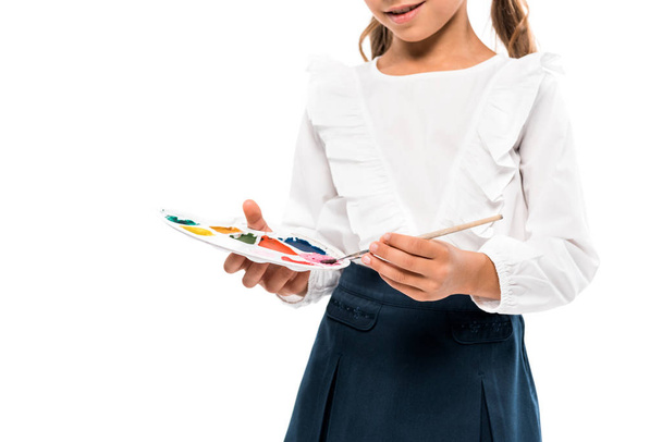 vue recadrée d'un enfant heureux tenant une palette d'aquarelles isolée sur blanc
  - Photo, image
