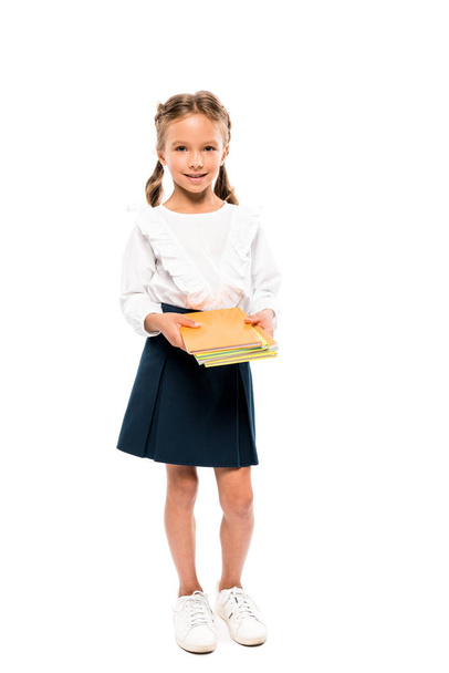Wesołe dziecko trzyma książki, stojąc na białym tle  - Zdjęcie, obraz