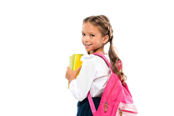 mosolygós gyermek állt rózsaszín hátizsák és könyvek elszigetelt fehér  - Fotó, kép