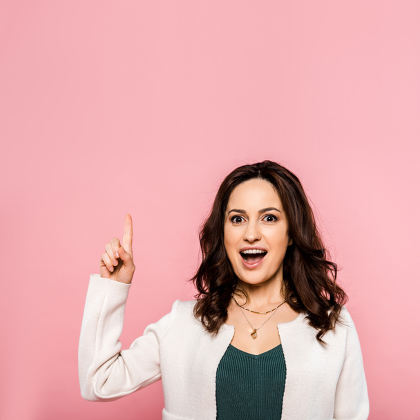 excited woman pointing with finger isolated on pink  - Foto, Bild