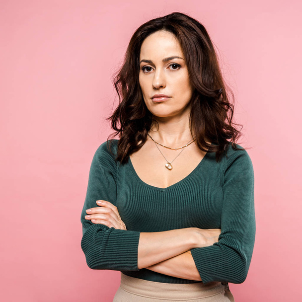 dissatisfied woman standing with crossed arms isolated on pink  - Photo, Image