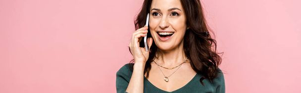 panoramic shot of happy woman talking on smartphone isolated on pink  - Fotoğraf, Görsel
