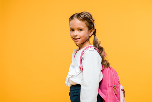 happy child with pink backpack smiling isolated on orange   - Foto, immagini