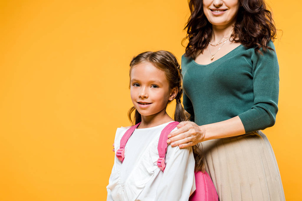 cropped view of mother touching shoulders of daughter isolated on orange  - Photo, Image
