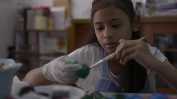 Ázsiai csinos lány teszi kézműves tojáshéjak az asztalra, fiatal lány színező tojáshéj otthon neki házi feladatát, oktatási koncepció. - Felvétel, videó