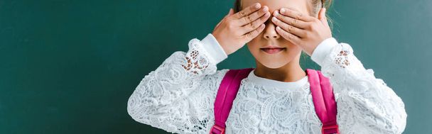 panoramic shot of cute kid covering eyes with hands on green  - Photo, Image