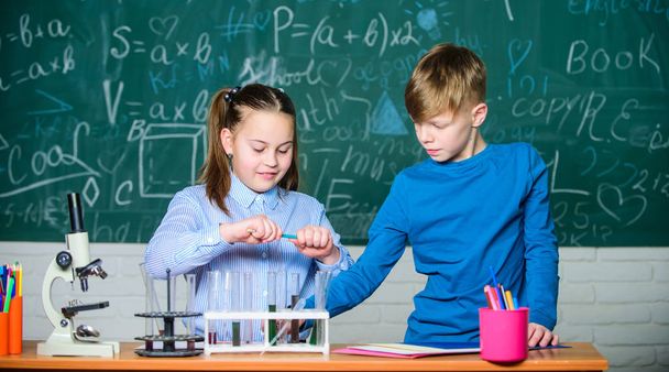 Chemical analysis. Kids busy study chemistry. School chemistry lesson. School laboratory. Describe chemical reaction notepad. School education. Girl and boy smart students conduct school experiment - Photo, image