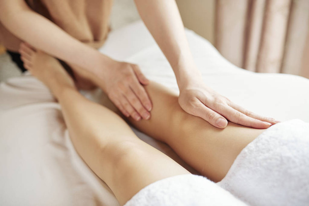 Close-up image of woman getting anti cellulite massage of legs in spa salon - Photo, Image