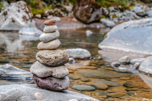 Cairn of balanced stones by the riverside - Photo, Image