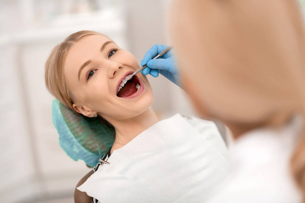 Dentist checking braces of her cheerful patient. - Valokuva, kuva